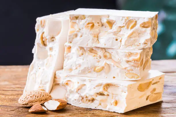 Torrone or nougat on wood background.