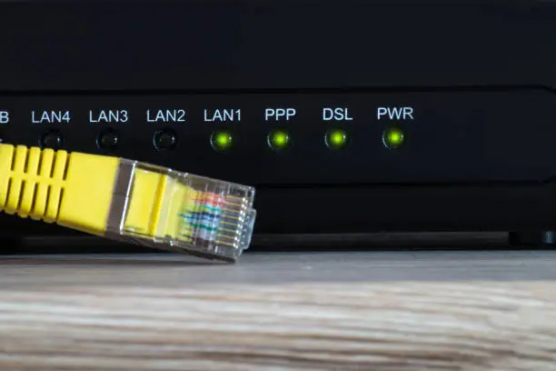a dsl modem on a desk with status led and a yellow network cable