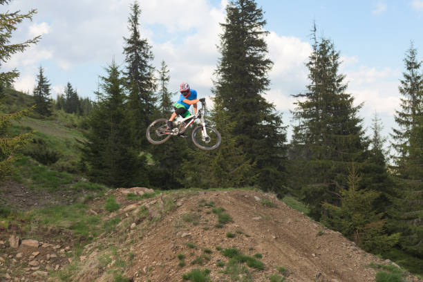 istock Man catching air with mtb while riding downhill rough slope 813865124