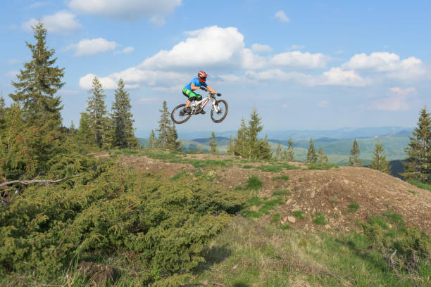 istock Cyclist perfroming midair tricks with dirt bike on rough terrain 813865492