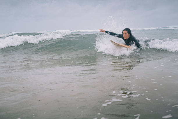 istock Female Surfer Paddling on surfboard, Perranporth, Cornwall 813865510
