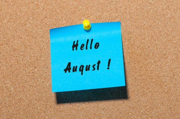 istock Hello August on blue sticker pinned to cork noticeboard 813884604