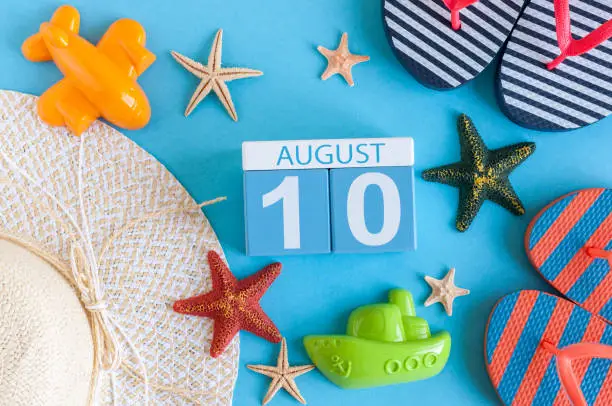 Photo of August 10th. Image of August 10 calendar with summer beach accessories and traveler outfit on background. Summer day, Vacation concept