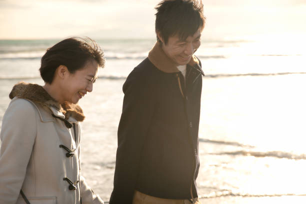 istock couple walking on the beach 813889040