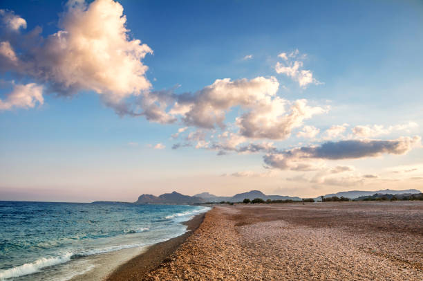 Tramonto sulla spiaggia di Afandou (baia di Afantou), isola di Rodi, Grecia - foto stock