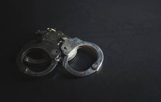 istock police handcuffs on a dark background with copy space, over light [blur and select focus background] 813898912