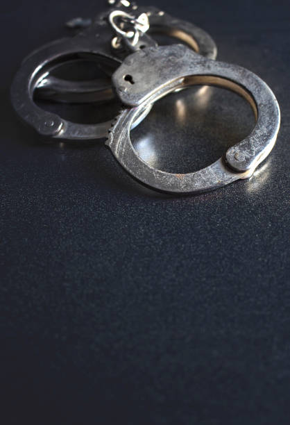 istock police handcuffs on a dark background with copy space, over light [blur and select focus background] 813898922