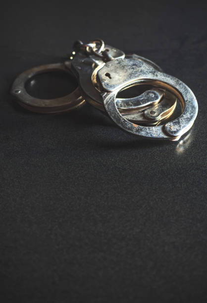 istock police handcuffs on a dark background with copy space, over light [blur and select focus background] 813898928