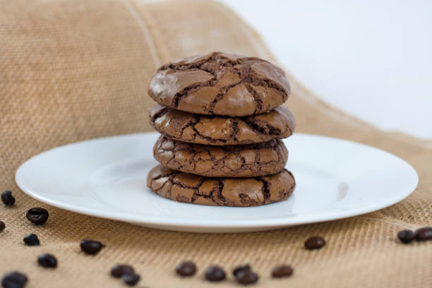 istock Black Brownie Cookies on a white plate and a rustic burlap background 813901486