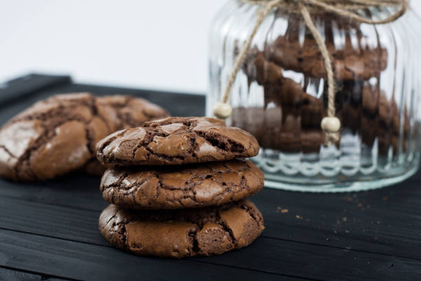istock Black Brownie Cookies on a black table and glass jar 813901618