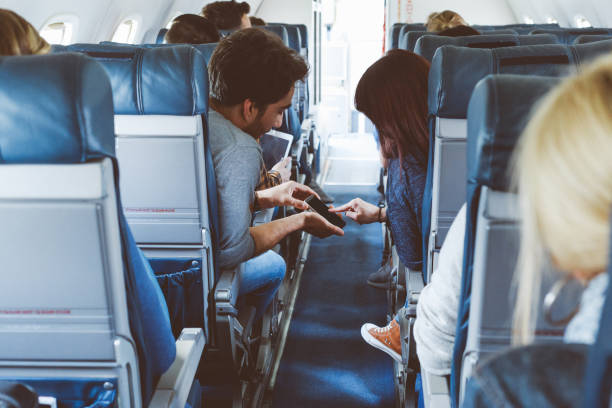 istock Young couple using mobile phone in the flight 813901948