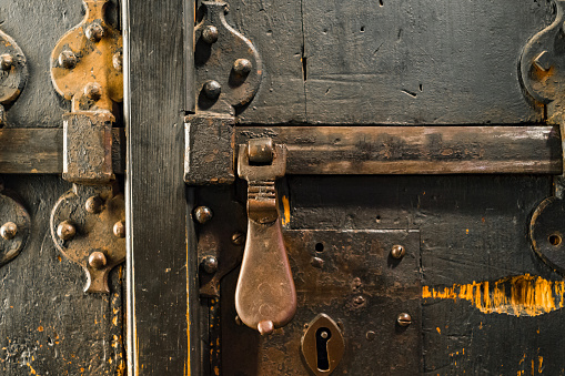 aged ancient wooden door with vintage metal latch in Matera, south Italy.