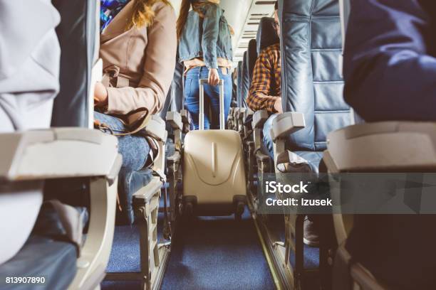Interior Of Airplane With People Sitting On Seats Stock Photo - Download Image Now - Airplane, Boarding, Aisle
