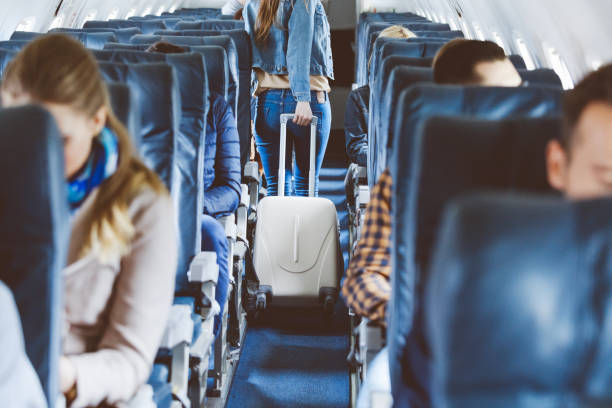 istock Airplane interior with people sitting on seats 813910398