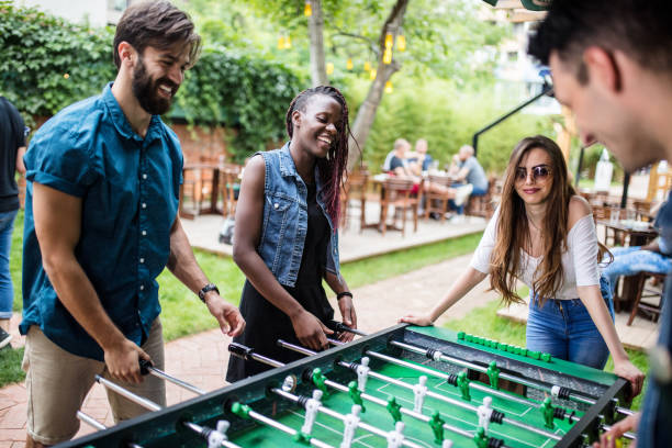 istock Multi-ethnic group of people playing foosball at the bar 813910626