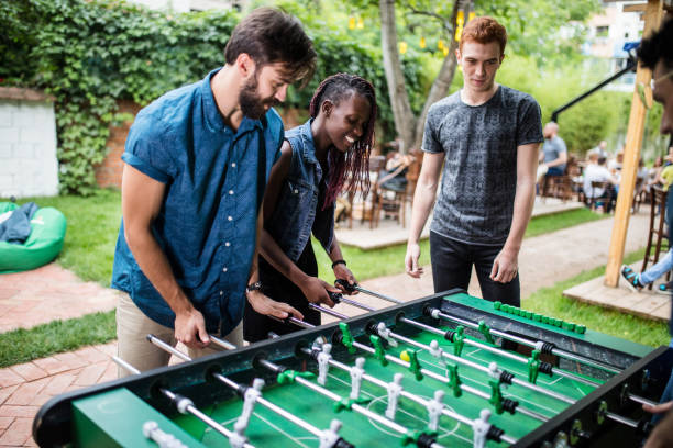 istock Multi-ethnic group of people playing foosball at the pub 813910756