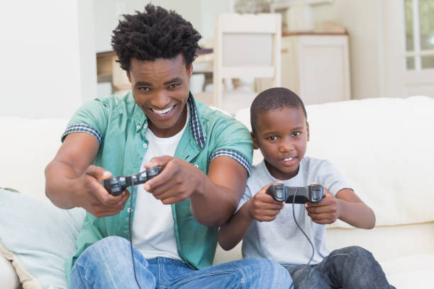 istock Father and son playing video games together 813915314