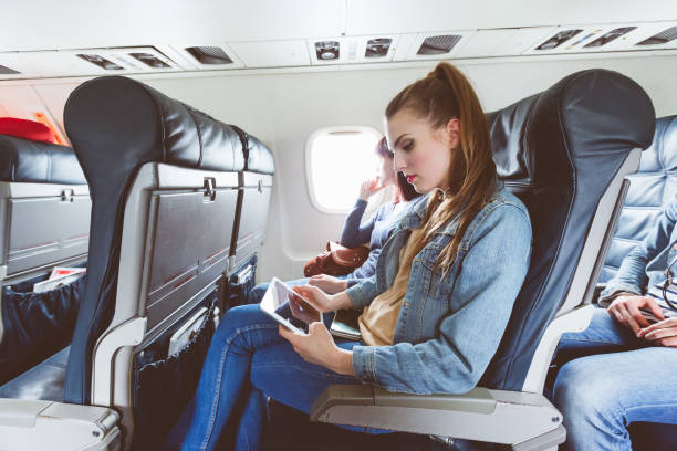 istock Beautiful young woman traveling by plane using digital tablet 813916160
