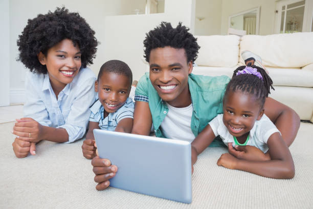 istock Happy family lying on the floor using tablet 813919952