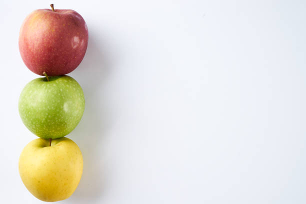 três maçãs cores diferentes parece luz de tráfego. maçãs vermelhas, verdes e amarelas isoladas no fundo branco, com espaço de cópia. - apple granny smith apple three objects green - fotografias e filmes do acervo