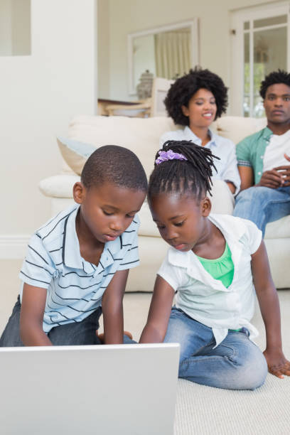 istock Happy siblings lying on the floor using laptop 813926732