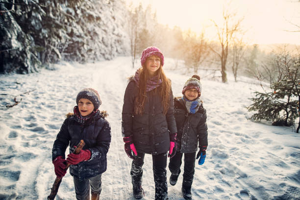 istock Three kids hiking in beautiful winter forest 813927504