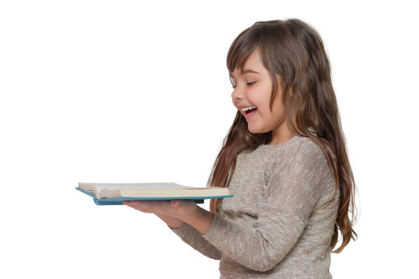 Caucasian little girl child reading book over white background. Kid holding brown book cover hide her face - Clipping path