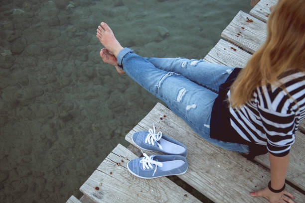 Young woman sitting and relaxes on pier