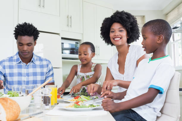 istock Happy family sitting down to dinner together 813971540
