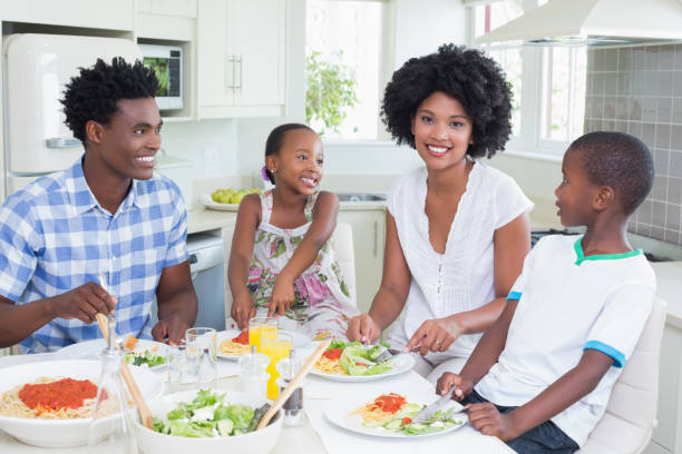 istock Happy family sitting down to dinner together 813972536