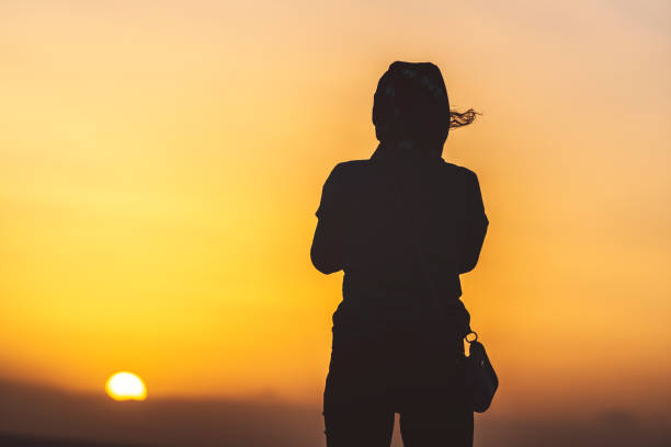 istock Woman silhouette in the morning sun 813972798