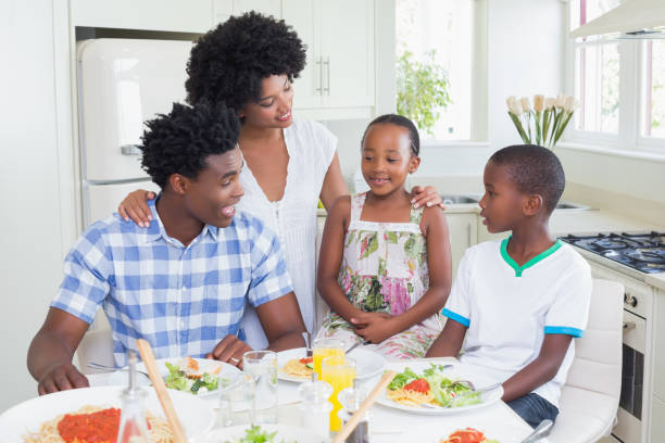 istock Happy family sitting down to dinner together 813973110