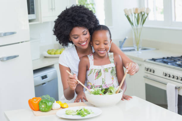 istock Mother and daughter making a salad together 813979694