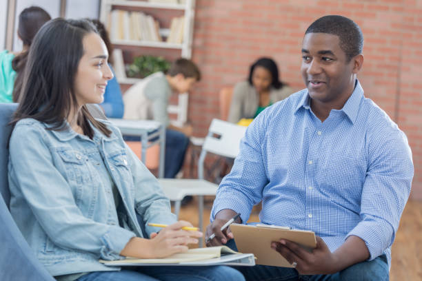 istock African American male teacher helps female student with assignment 813980096