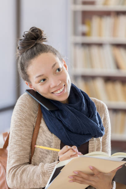 istock Beautiful female college student talks on smart phone 813980170