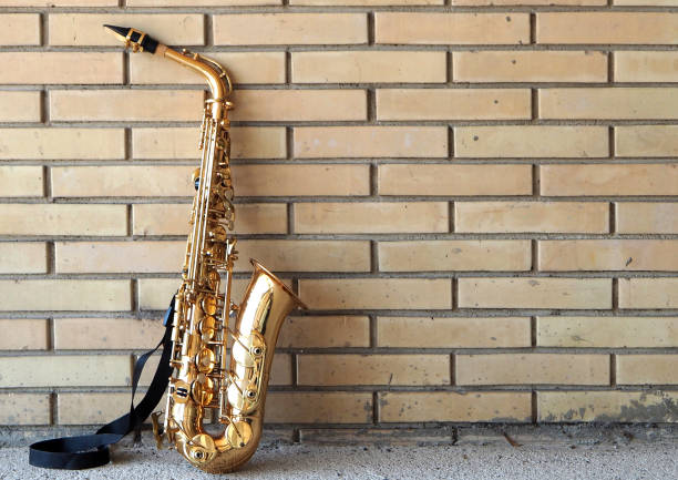 istock Saxophone leaning against a yellow brick wall 813983596
