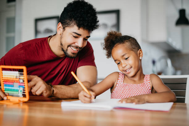istock Cute girl is doing math with a help of her dad 813992424