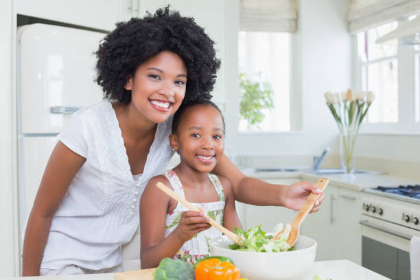istock Mother and daughter making a salad together 813996264