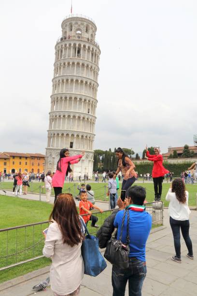 Leaning Tower of Pisa Tourists pose and take photos with Leaning Tower of Pisa, Italy. Pisa has population of 90 thousand people and is a popular tourism destination in Tuscany. pisa leaning tower of pisa tower famous place stock pictures, royalty-free photos & images