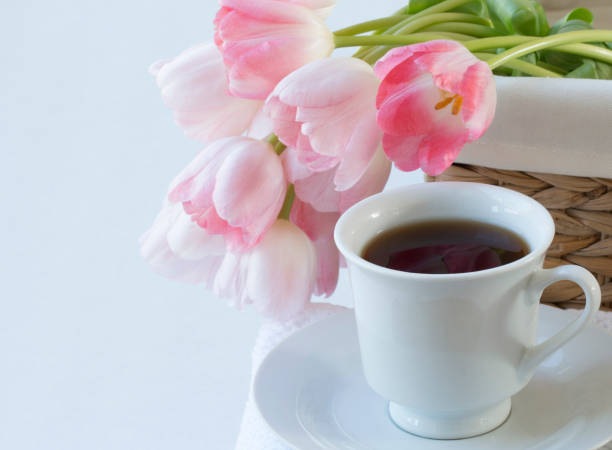 istock white cup of black coffee with pink tulip on  white background 814036120