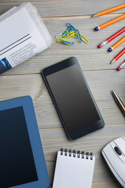 istock Smartphone next to the newspaper notepad tablet and pen 814050734