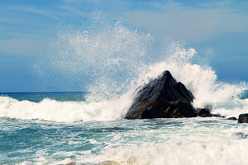 Scenic water splash and a rock in ocean