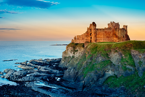 Tantallon Castle, east of North Berwick, Scotland, in evening light. Dating back over six centuries, the castle has been beseiged three times, with its soft sandstone walls pockmarked with strikes from cannonballs.