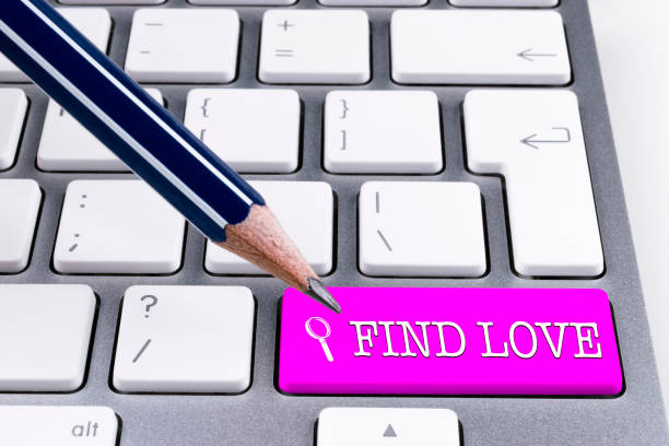 istock Close up view of a Computer notebook keyboard with office pencil and one pink button FIND LOVE, technology background, empty space for text 814077198