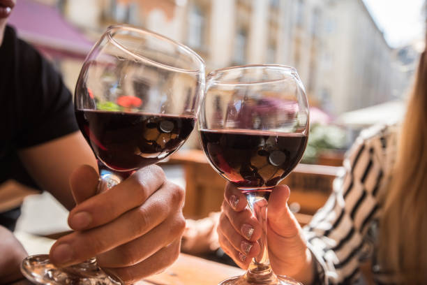 シティー ビュー レストランで赤ワインのグラスを持つ若いカップルします。 - bentham ストックフォトと画像