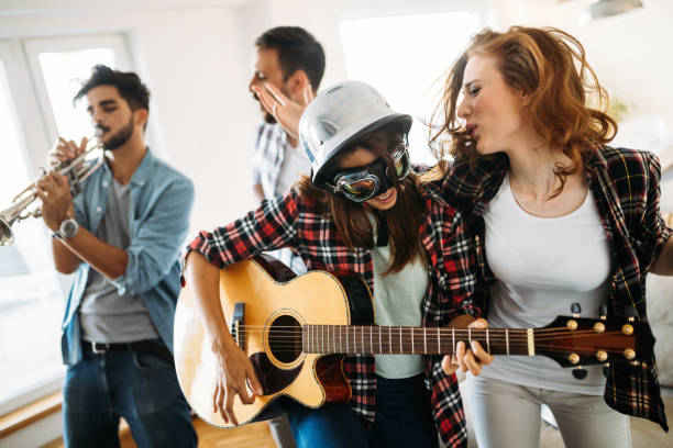 istock Cheerful friends having party together and playing instruments 814087272
