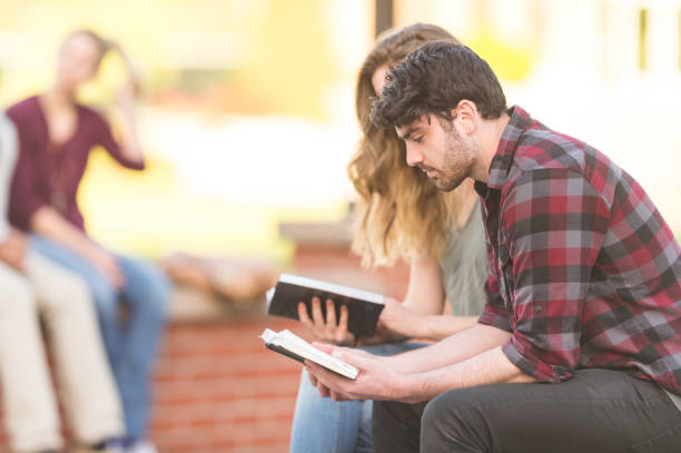 istock Two college students - a male and female - study together on a park bench 814101702