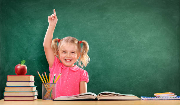 happy girl, levant la main en classe - blackboard child thinking little girls photos et images de collection