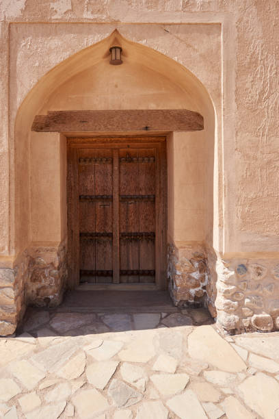 istock Old Wooden door set in an earthen wall 814113480