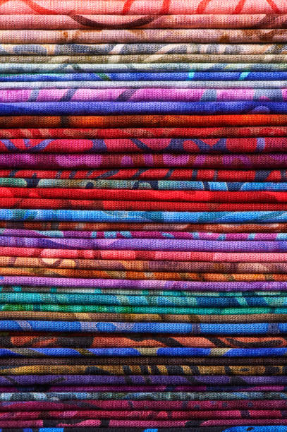 pila di tessuti batik colorati come immagine di sfondo vibrante - patch textile stack heap foto e immagini stock